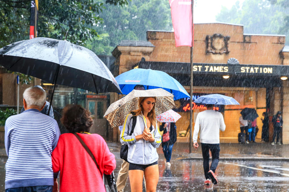 People are seen in Sydney's CBD as rain falls.