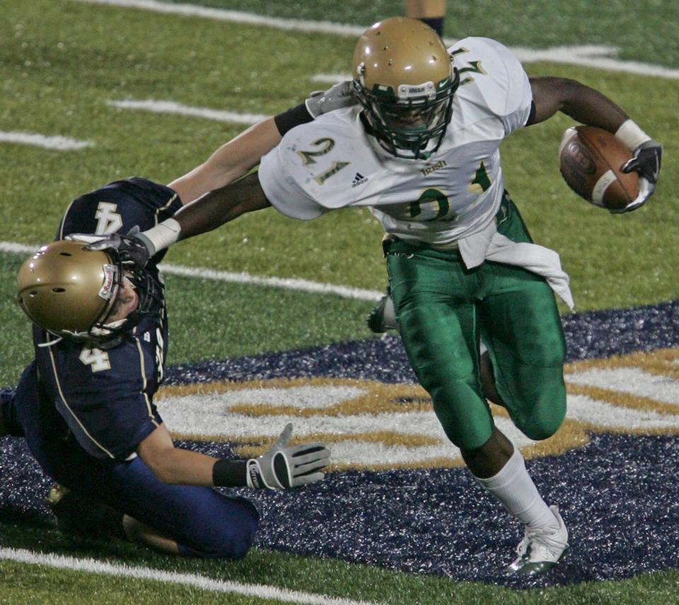 Archbishop Hoban defender Evan Luse (left) is stiff-armed while trying to tackle St. Vincent-St. Mary running back Doran Grant during first-half action Sept. 18, 2009, in Akron.