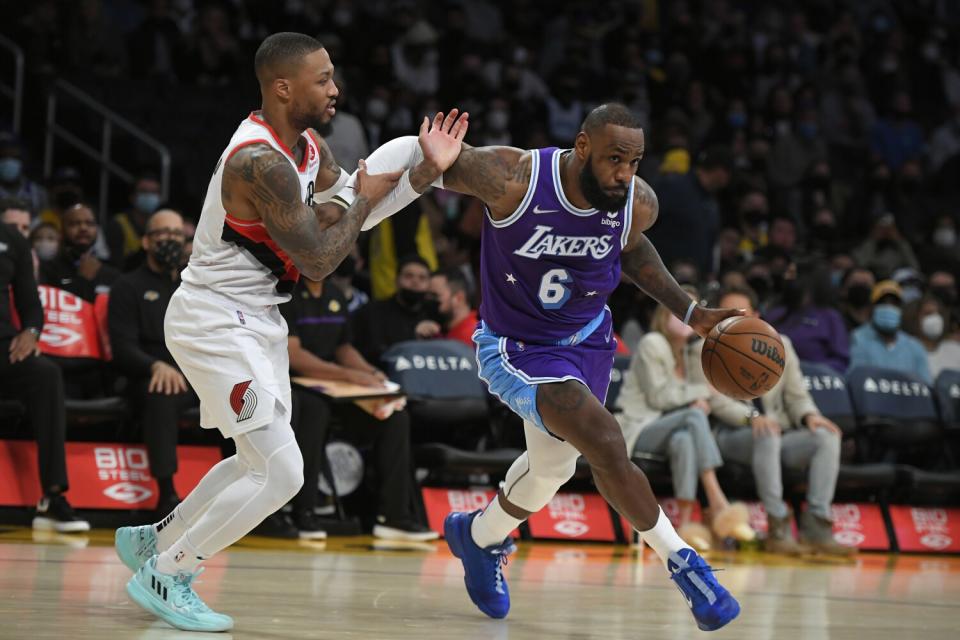 LeBron James, right, drives around Portland Trail Blazers guard Damian Lillard during the first half.