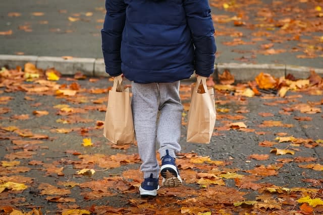 A child collects packed lunch bags 