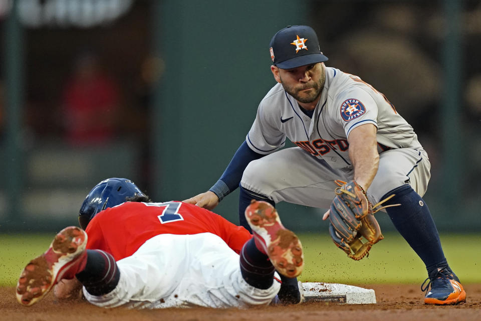 Atlanta Braves' Dansby Swanson (7) dives back to second base safely as Houston Astros second baseman Jose Altuve (27) handles the late throw in the forest inning of a baseball game Friday, Aug. 19, 2022, in Atlanta. (AP Photo/John Bazemore)