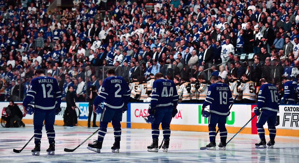 Players and fans stand for a moment of silence, after nine people died and 16 others were injured when a van mounted a sidewalk and struck multiple pedestrians along a stretch of one of Toronto’s busiest streets. (Frank Gunn/CP)