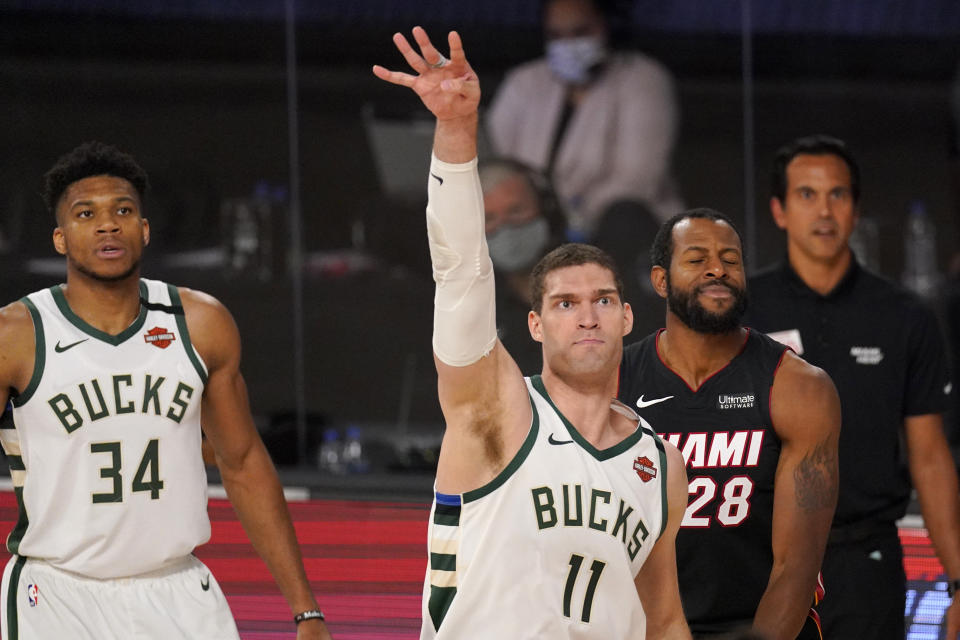 Milwaukee Bucks' Brook Lopez (11) watches his shot sink as Giannis Antetokounmpo (34) and the Miami Heat's Andre Iguodala (28) look on during the second half of an NBA basketball conference semifinal playoff game, Monday, Aug. 31, 2020, in Lake Buena Vista, Fla. (AP Photo/Mark J. Terrill)