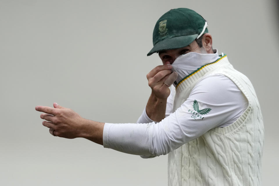 South Africa's Dean Elgar jokes with Australia's Matt Renshaw pretending to mask his face after Renshaw tested positive for COVID-19 during the second day of their cricket test match at the Sydney Cricket Ground in Sydney, Thursday, Jan. 5, 2023. (AP Photo/Rick Rycroft)