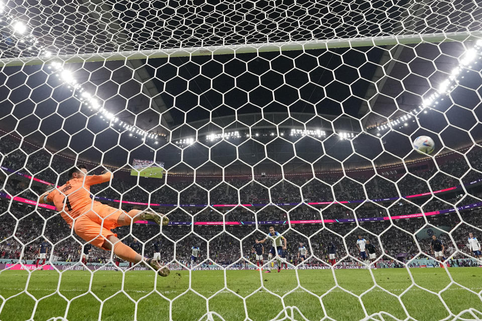 England's Harry Kane scores his side's first goal from the penalty spot past France's goalkeeper Hugo Lloris during the World Cup quarterfinal soccer match between England and France, at the Al Bayt Stadium in Al Khor, Qatar, Saturday, Dec. 10, 2022. (AP Photo/Frank Augstein)