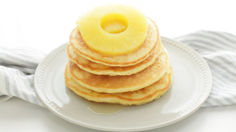 Sliced pineapple on stacked pancakes
