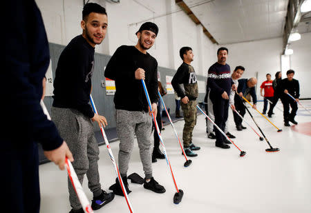 A refugee family from Afghanistan take to the ice to learn the sport of curling at the Royal Canadian Curling Club during an event put on by the "Together Project", in Toronto, March 15, 2017. REUTERS/Mark Blinch