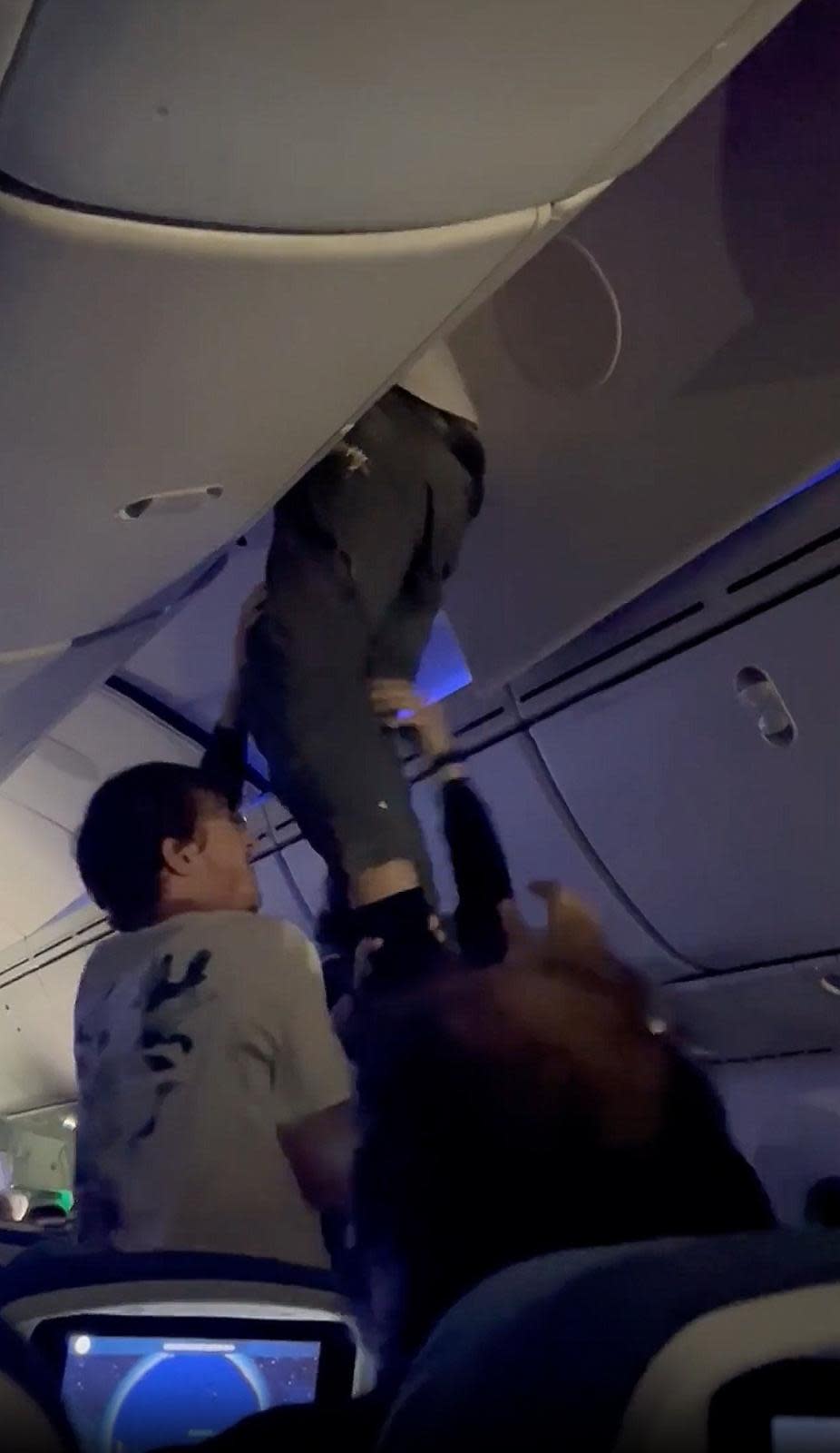 PHOTO: A man is seen dangling from the overheard compartment of an Air Europa following severe turbulence, July 1, 2024. It is unclear how he ended up there. (@Natalia_gimeno)