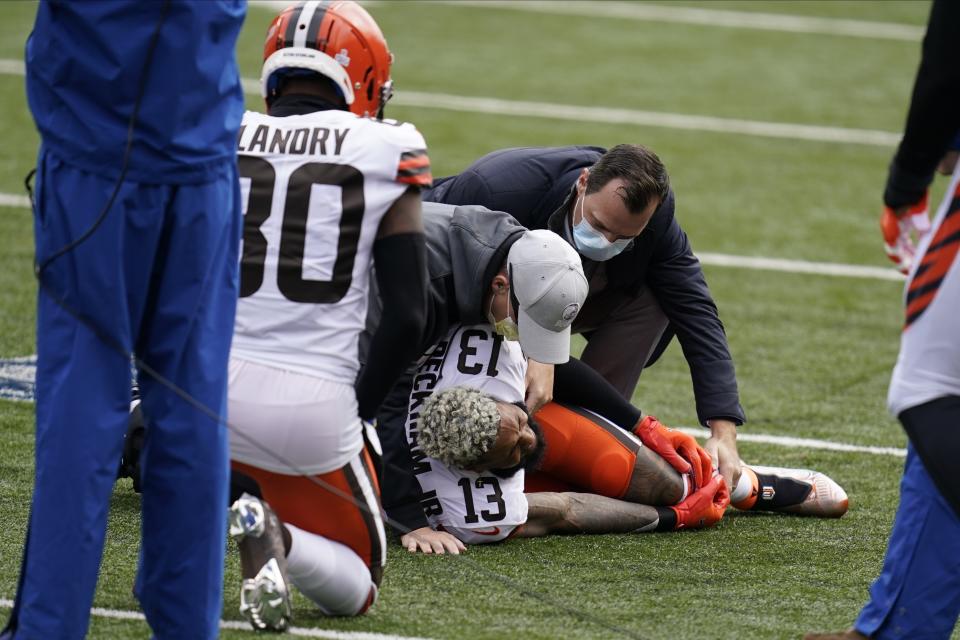 Cleveland Browns' Odell Beckham Jr. (13) is examined during the first half of an NFL football game against the Cincinnati Bengals, Sunday, Oct. 25, 2020, in Cincinnati. Browns star wide receiver Odell Beckham Jr. will miss the rest of the season after tearing a knee ligament during Sunday's 37-34 win at Cincinnati. (AP Photo/Michael Conroy)