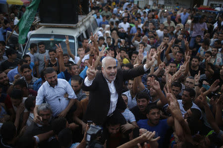 Hamas spokesman Fawzi Barhoum is carried by Palestinians as they celebrate what they said was a victory over Israel following a ceasefire in Gaza City