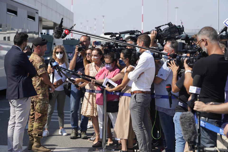 Colonel Diego Giarrizzo, head of evacuation operation “Aquila Omnia” talks to reporters at Rome's Fiumicino international airport, Wednesday, Aug. 18, 2021 as they wait for the disembark of 86 evacuees arriving from Kabul, Afghanistan with an airlift. (AP Photo/Gregorio Borgia )