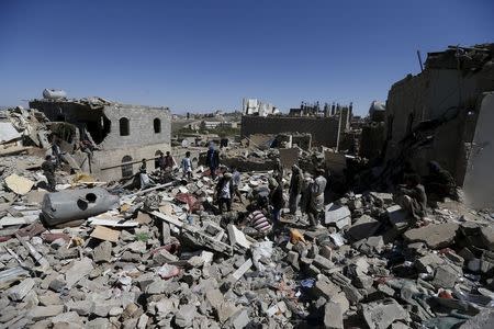 People stand amidst the rubble of houses destroyed by an overnight Saudi-led air strike on a residential area in Yemen's capital Sanaa May 1, 2015. REUTERS/Khaled Abdullah