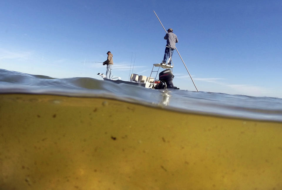 Men fishing in murky waters of Mosquito Lagoon