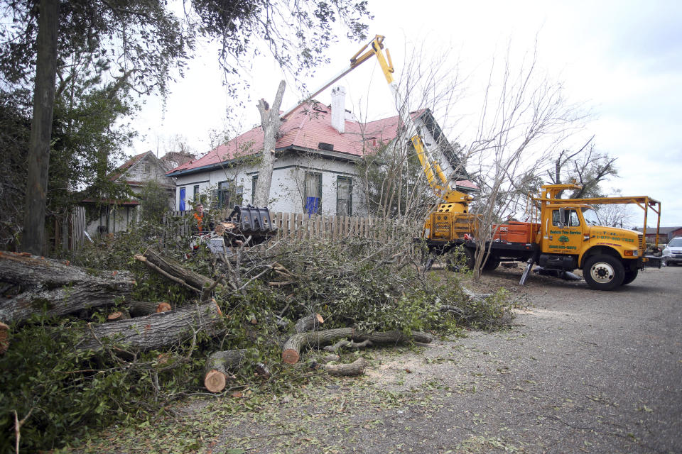 Workers remove a downed tree from a house in Selma, Ala., Friday, Jan. 13, 2023, after a tornado passed through the area. Rescuers raced Friday to find survivors in the aftermath of a tornado-spawning storm system that barreled across parts of Georgia and Alabama. (AP Photo/Stew Milne)