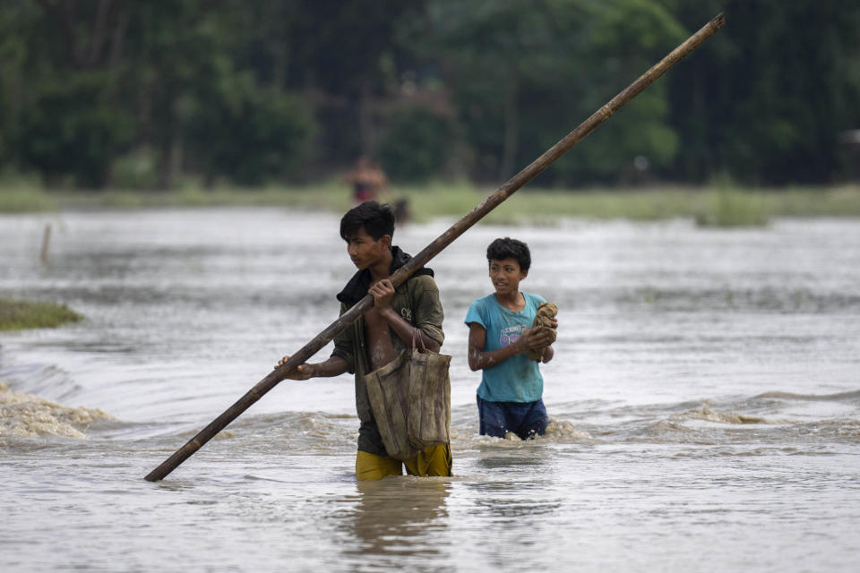 Boys wade through floodwaters in Bali village, west of Guwahati, India, Friday, June 23, 2023. Tens of thousands of people have moved to relief camps with one person swept to death by flood waters caused by heavy monsoon rains battering swathes of villages in India’s remote northeast this week, a government relief agency said on Friday. (AP Photo/Anupam Nath)