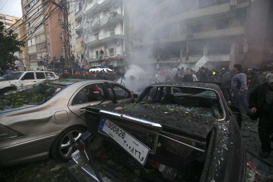 People inspect the site of an explosion in Beirut's southern suburbs