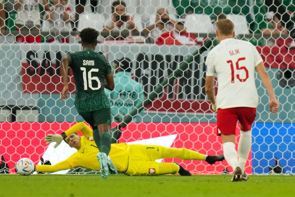 Poland's goalkeeper Wojciech Szczesny, bottom, dives to save a penalty shot by Saudi Arabia's Salem Al-Dawsari, right, during the World Cup group C football match between Poland and Saudi Arabia, at the Education City Stadium in Al Rayyan, Qatar, Saturday, Nov. 26, 2022. (AP Photo/Francisco Seco)