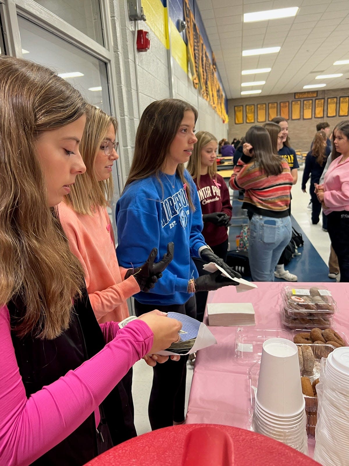 Members of the Port Huron Northern Connecting with Cancer club selling apple cider and donuts on Oct. 18, 2023.
