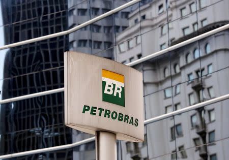 The Petrobras logo is seen in front of the company's headquarters in Sao Paulo April 23, 2015. Executives at Brazil's Petrobras on Thursday sought to move on from a giant corruption scandal that has plagued the state-run oil company, outlining a back-to-basics recovery plan that left some investors hoping the worst was over. On a call with investors the day after publishing long-delayed audited results for 2014, Chief Financial Officer Ivan Monteiro said the focus was on reducing debt, selling non-core assets and continuing to increase oil production through careful investments in high-return assets. REUTERS/Paulo Whitaker - RTX1A1LN