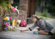 <p>Megan O’Leary, of St. Paul, leaves a message on the sidewalk near the scene where a Minneapolis police officer shot and killed Justine Damond, of Australia, Monday, July 17, 2017, in Minneapolis, Minn.(Photo: Elizabeth Flores/Star Tribune via AP) </p>