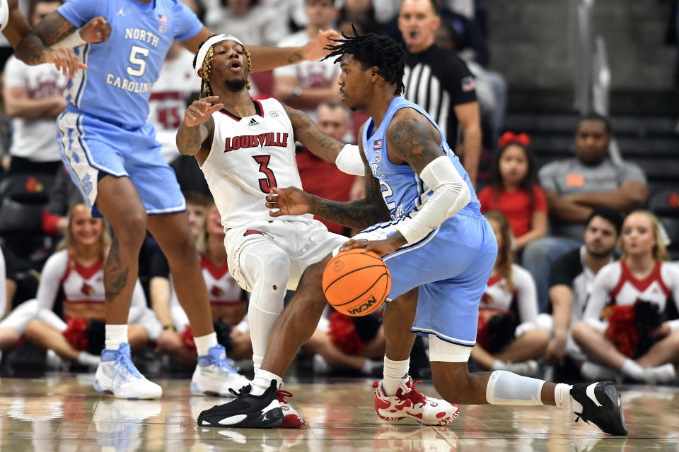North Carolina guard Caleb Love (2) charges into Louisville guard El Ellis (3) during the second half of an NCAA college basketball game in Louisville, Ky., Saturday, Jan. 14, 2023. North Carolina won 80-59. (AP Photo/Timothy D. Easley)