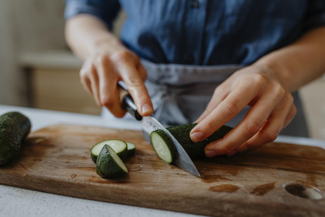 Anonymous woman chopping fresh vegetables for a salad, a close up.