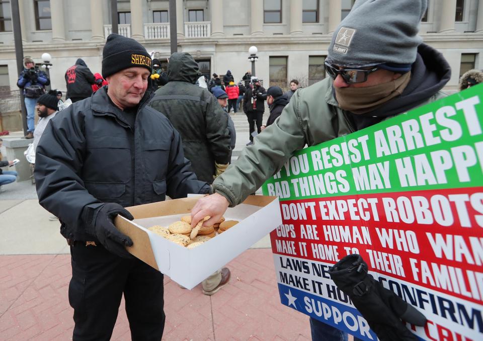 Kenosha County Sheriff David G. Beth passes out cookies outside the Kenosha County Courthouse during the trial of Kyle Rittenhouse on Thursday, a day before the teenager was found not guilty on all counts.