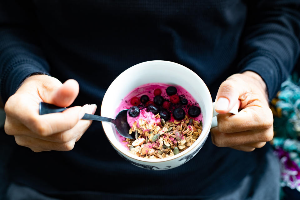 A man holding an açai and granola bowl.