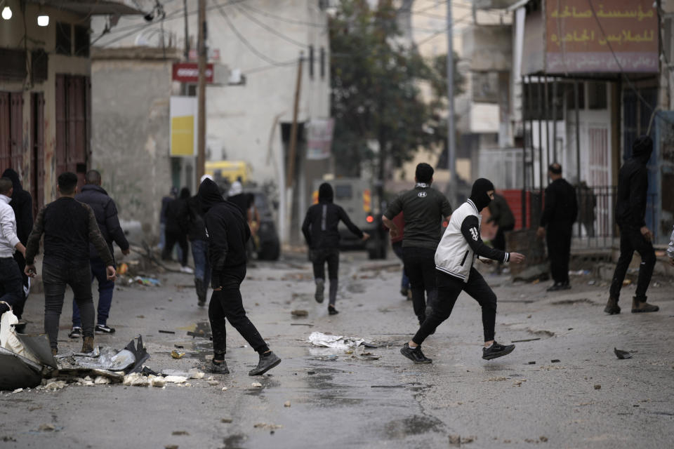 Palestinians clash with Israeli forces raiding Aqbat Jabr camp, southwest of the city of Jericho on Saturday, Feb. 4, 2023, during a search for the Palestinian suspects behind a shooting attack at a restaurant in a nearby settlement last week. The army said it surrounded several residences that Palestinians were using to hide out and plan future attacks and ultimately arrested several suspects who surrendered. During the raid, the army said Palestinian protesters shot at Israeli security forces, who responded with live fire. The Palestinian Health Ministry said six people were wounded, two seriously. (AP Photo/ Majdi Mohammed)