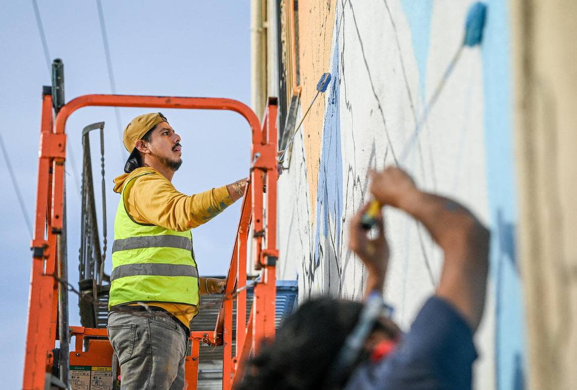 Fresno muralist Mauro Carrera, left, works with Rigo Garcia on a mural on a historical Chinatown building on China Alley in downtown Fresno on Thursday, Dec. 8, 2022. The project is in conjunction with the Fresno Arts Council and the California High-Speed Rail Authority.