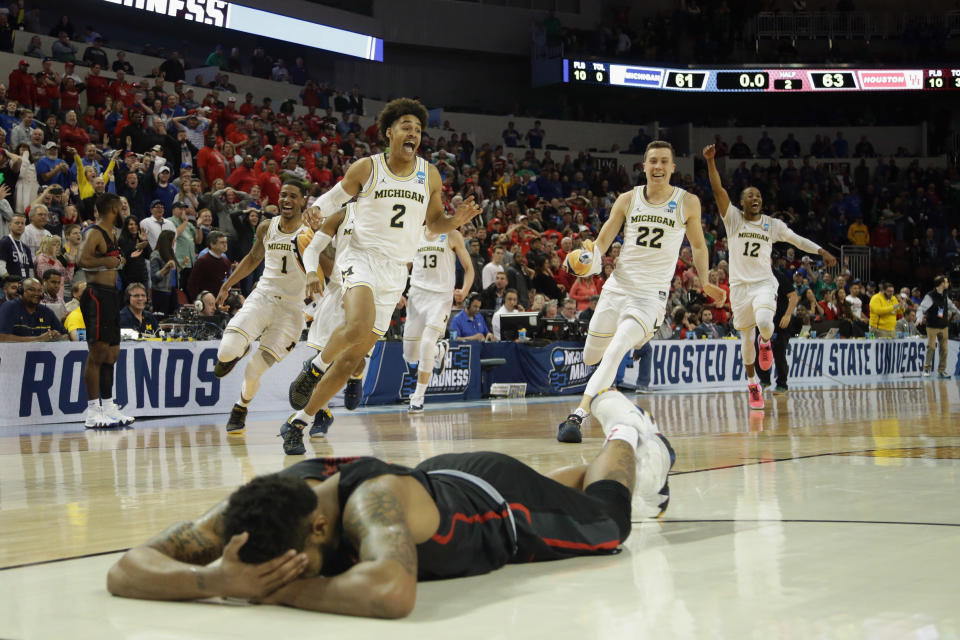 Michigan players celebrate Jordan Poole’s buzzer-beater as Houston’s Devin Davis lies face-down on the court. (Getty)