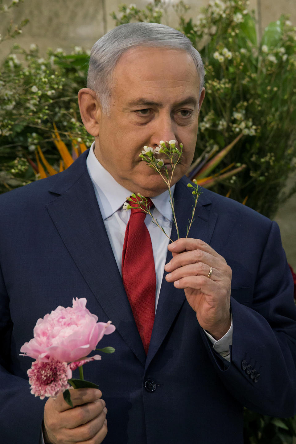 Israeli Prime Minister Benjamin Netanyahu smells a flower during an exhibition of Israeli agricultural produce ahead of the weekly cabinet meeting at the Prime Minister's office in Jerusalem January 28, 2018. REUTERS/Tsafrir Abayov/Pool