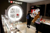 Visitors take pictures at the exhibition stand of Swiss watch manufacturer Tissot at the Baselworld Watch and Jewellery Show in Basel, Switzerland March 23, 2017. REUTERS/Arnd Wiegmann