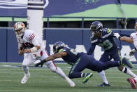 San Francisco 49ers quarterback Jimmy Garoppolo, left, is sacked by Seattle Seahawks middle linebacker Bobby Wagner, center, as D.J. Reed (29) looks on during the first half of an NFL football game, Sunday, Nov. 1, 2020, in Seattle. (AP Photo/Elaine Thompson)