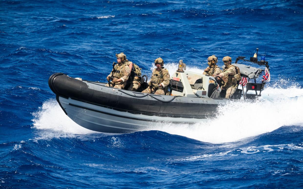 Marines and US Coast Guards on small boat pursuing the alleged smugglers' speedboat