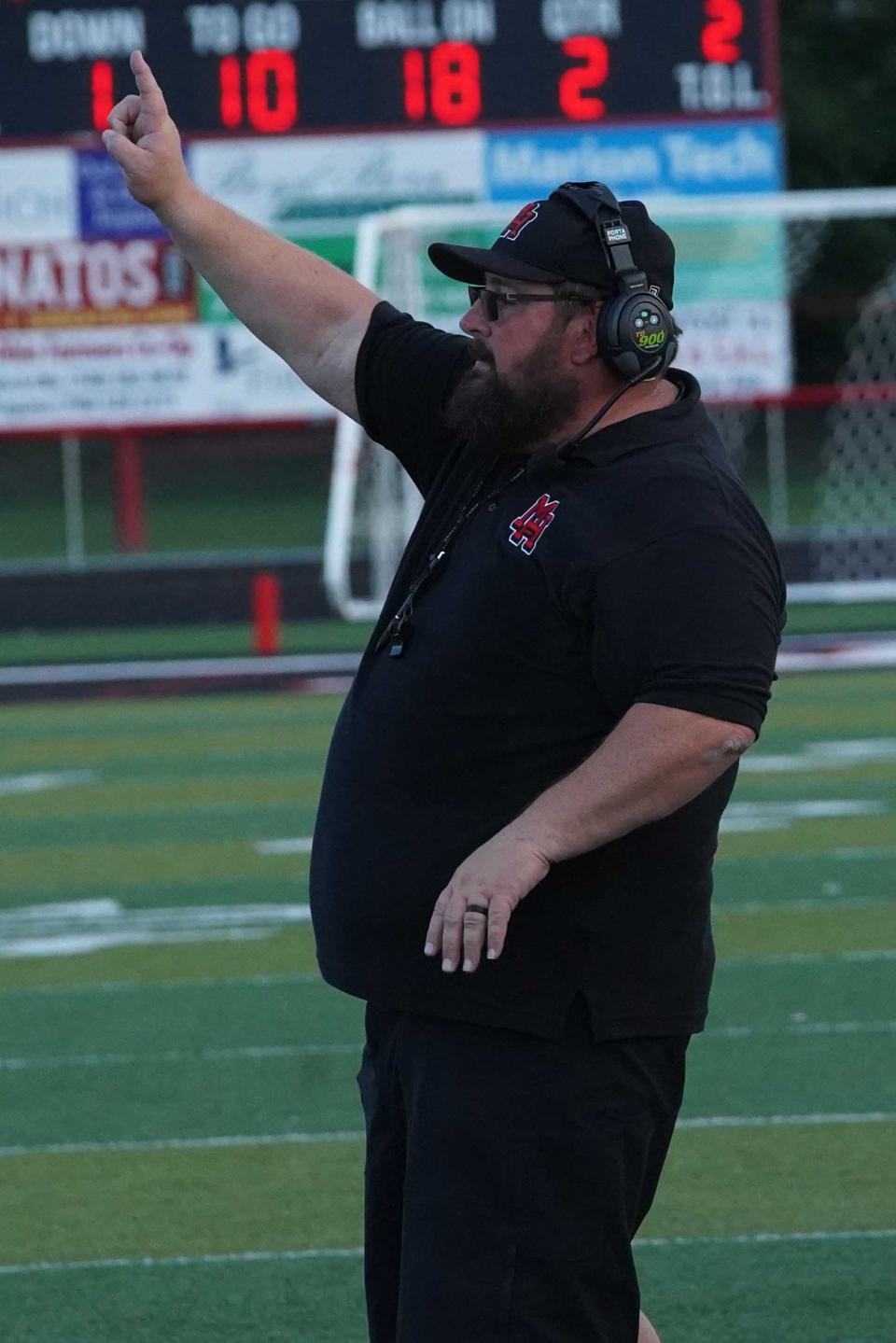 Marion Harding head football coach Dan Arndt signals in a play during Friday's home opener in Harding Stadium against Mount Vernon.