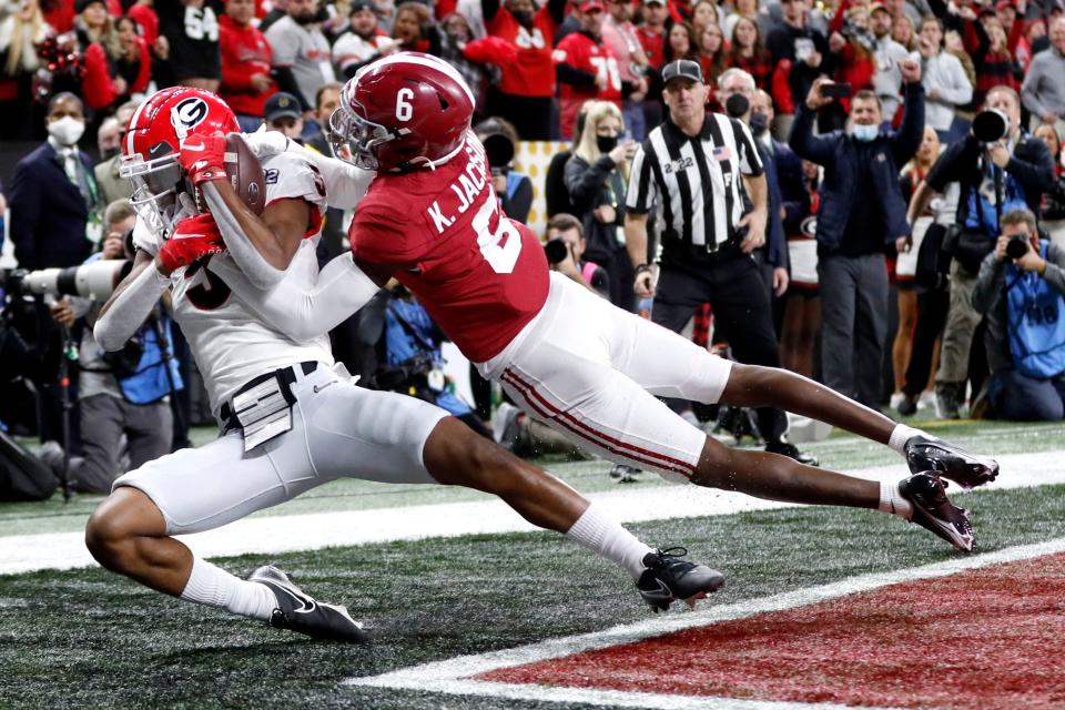 Georgia wide receiver Adonai Mitchell (5) makes a touchdown catch while being guarded by Alabama defensive back Khyree Jackson (6) during the College Football Playoff championship game at Lucas Oil Stadium in Indianapolis, Monday, Jan. 10, 2022.