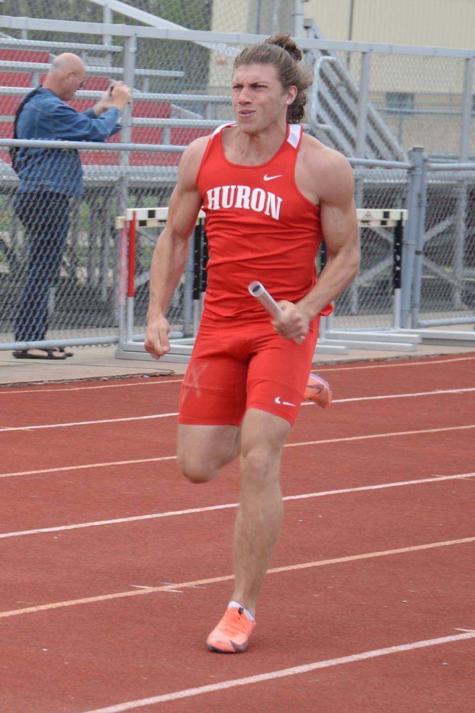 Caleb Heinninger runs the anchor leg of New Boston Huron’s winning 400-meter relay Tuesday.