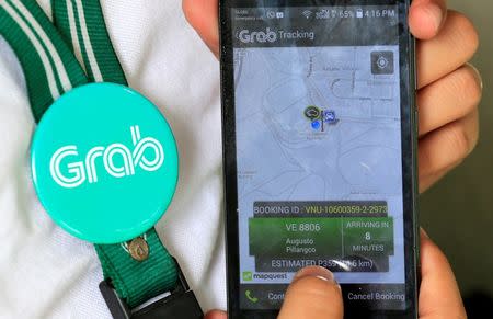 A Grab employee shows the Apps used to book a cab in the metro Manila, Philippines July 22, 2016. REUTERS/Romeo Ranoco