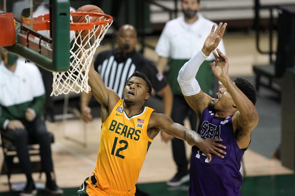Baylor guard Jared Butler (12) goes up for a shot as Stephen F. Austin's Gavin Kensmil, right, defends in the second half of an NCAA college basketball game in Waco, Texas, Wednesday, Dec. 9, 2020. (AP Photo/Tony Gutierrez)