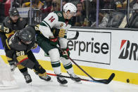 Vegas Golden Knights left wing William Carrier (28) vies for the puck with Minnesota Wild center Joel Eriksson Ek (14) during the third period of an NHL hockey game Monday, May 24, 2021, in Las Vegas. (AP Photo/John Locher)