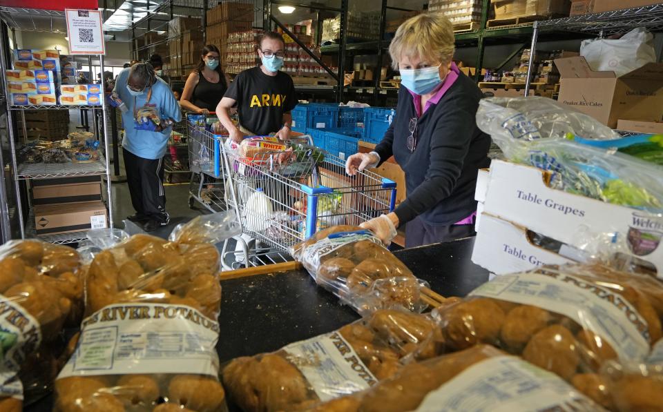 May 3, 2022; Columbus, Ohio, United States; Volunteer Laurie Chapman loads potatoes for Johnathon Gillespie and Neleah McDowell at the Lutheran Social Services food pantry.  Mandatory Credit: Doral Chenoweth-The Columbus Dispatch