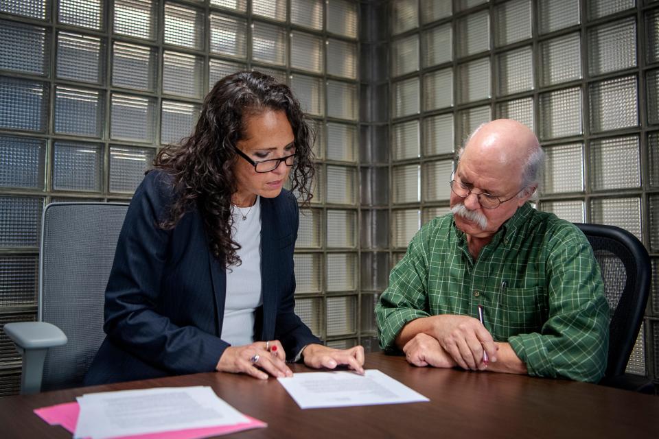 Asheville Citizen Times Executive Editor Karen Chávez, left, and Gene Hyde, Head of Special Collections at UNC Asheville's Ramsey Library, review a contract Nov. 6, 2023. The Citizen Times is donating its photo archives, dated 1870-2000, to the library, where it will become the university's newest and largest photo collection.