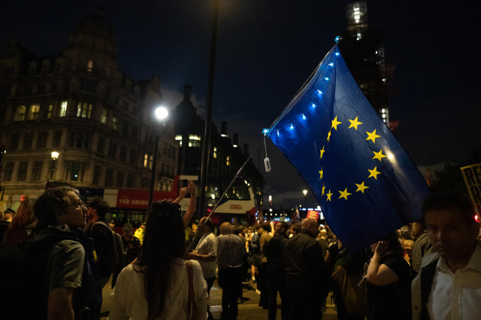 Hundreds of people are seen protesting against Boris Johnson outside the houses of parliament on Westminster bridge