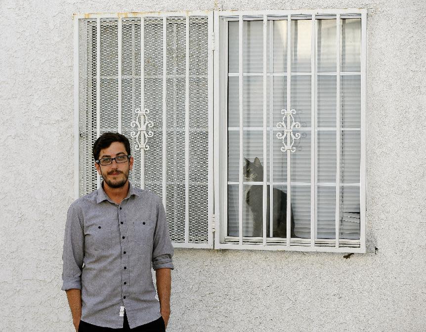In this Thursday, March, 27, 2014 photo, Marc Caswell, who recently moved from San Francisco to Los Angeles, poses for a photo in front of his newly rented apartment in the Los Feliz district of Los Angeles. Rising rents in San Francisco compelled Marc Caswell to move to Los Angeles in September. (AP Photo/Damian Dovarganes)