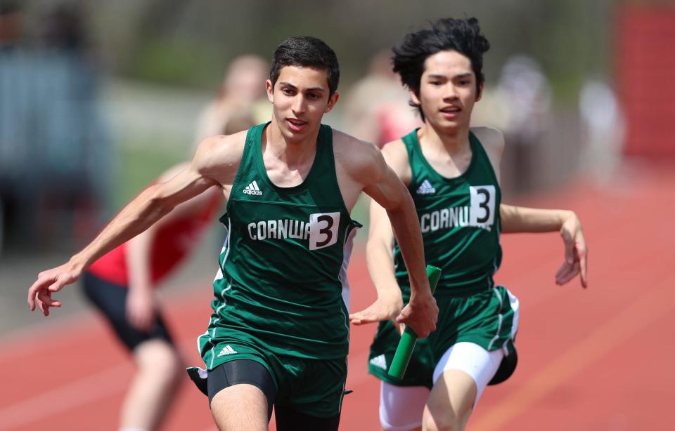 Cornwall's Avo Sarkissian (l) takes the baton from Charles Cypress in the boys distance medley relay during day 2 of the Red Raider Relays at North Rockland High School in Thiells on Saturday, April 23, 2022. Cornwall won the event in 10:45.57.