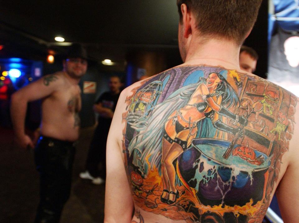 A man with a new school tattoo on his back in 2003.