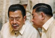 Manila Mayor Joseph Estrada, left, chats with Manila City Council member Bernardito Ang during a news conference in Hong Kong Wednesday, April 23, 2014. Hong Kong and the Philippines reached a compromise Wednesday over Hong Kong's demands for an apology for the families of eight tourists killed in a bungled response to a 2010 Manila hostage-taking that soured relations. (AP Photo/Kin Cheung)