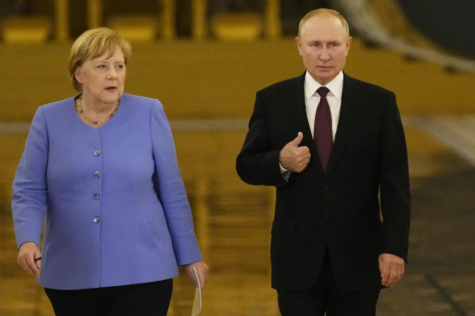 Russian President Vladimir Putin, right, and German Chancellor Angela Merkel enter the hall for a joint news conference following their talks in the Kremlin in Moscow, Russia, Friday, Aug. 20, 2021. The talks between Merkel and Putin are expected to focus on Afghanistan, the Ukrainian crisis and the situation in Belarus among other issues. (AP Photo/Alexander Zemlianichenko, Pool)