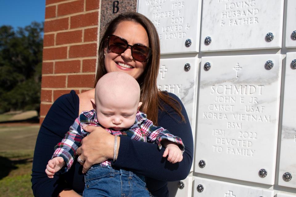 Adieren Mayfield holds her son Jackson next to his late great grandfather CMSGT John Schmidt Jr.Õs resting place at the Tallahassee National Cemetery on Wednesday, Nov. 8, 2023.